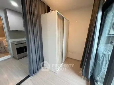 Modern apartment with sleek wardrobe and open layout near kitchen and bathroom.