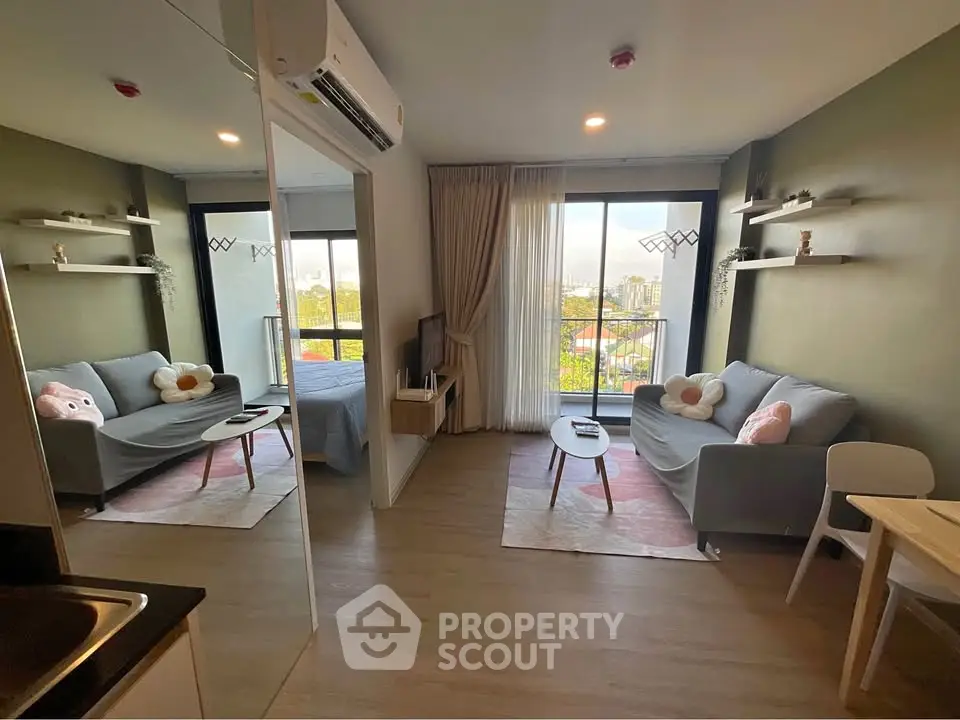Modern studio apartment with cozy living area and large windows offering a scenic view.