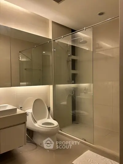 Modern bathroom with glass shower enclosure and sleek fixtures