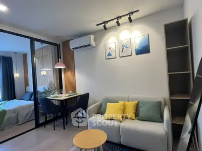 Modern living room with cozy sofa and stylish decor in open-plan apartment.