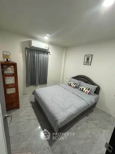 Cozy bedroom with modern decor and air conditioning, perfect for restful nights.