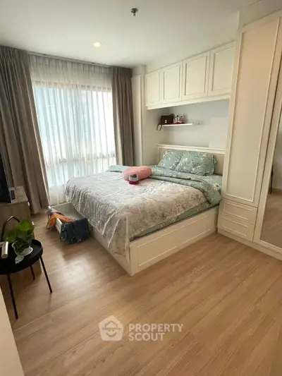 Cozy bedroom with large window and stylish decor in modern apartment