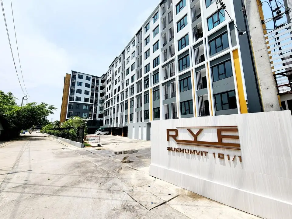 Modern apartment building exterior with sleek design at RYE Sukhumvit 101/1, showcasing urban living.