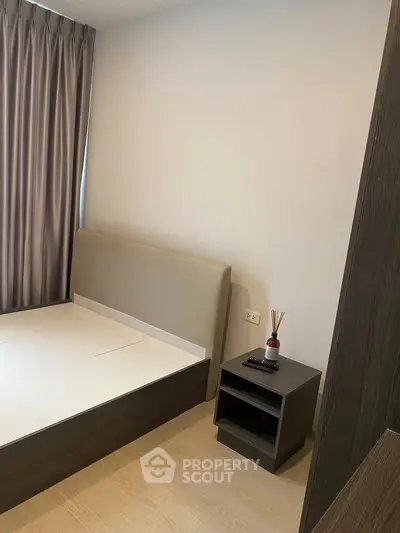 Modern bedroom with sleek bed frame and stylish nightstand in a cozy apartment.