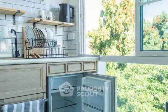 Bright kitchen with open fridge and scenic window view