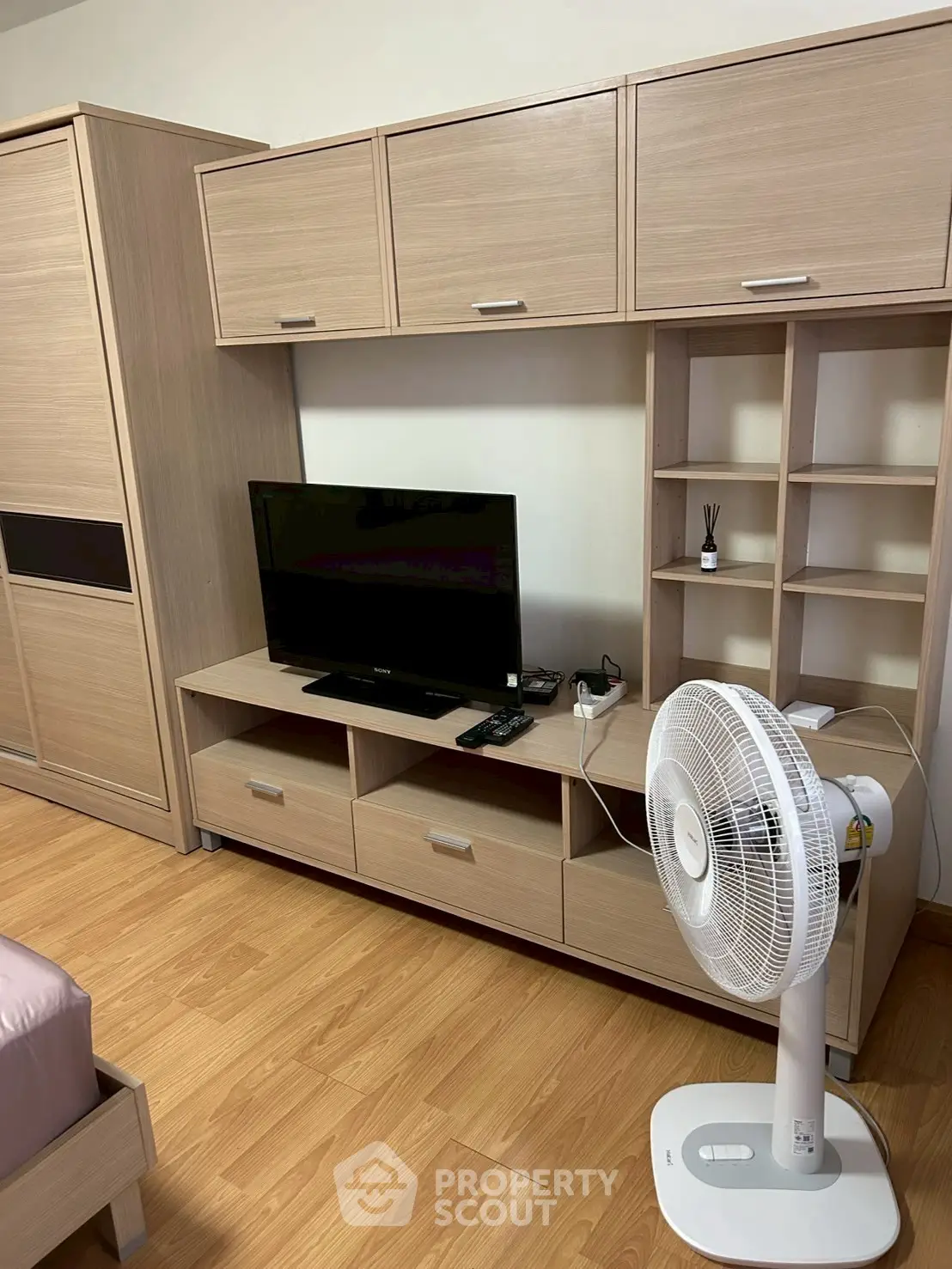 Modern bedroom with wooden furniture and TV setup