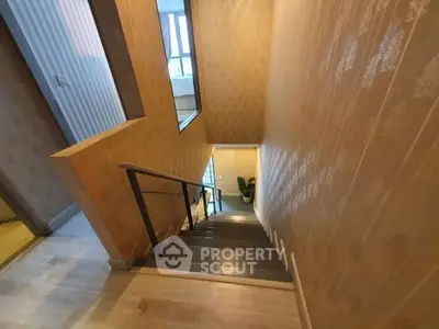 Stylish staircase with modern design and elegant wallpaper in a contemporary home.