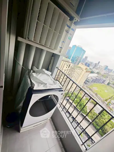 High-rise balcony with city view and laundry appliances, perfect for urban living.