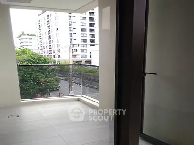 Modern apartment balcony with glass railing and city view