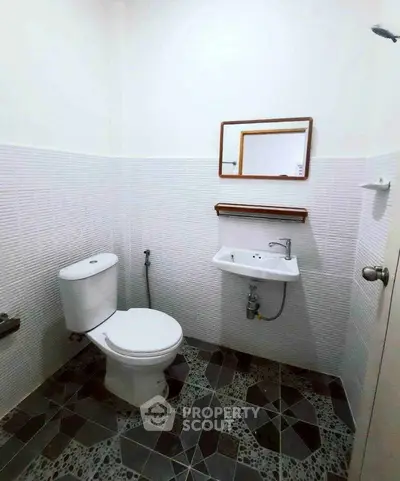 Compact bathroom with modern fixtures and geometric tile flooring
