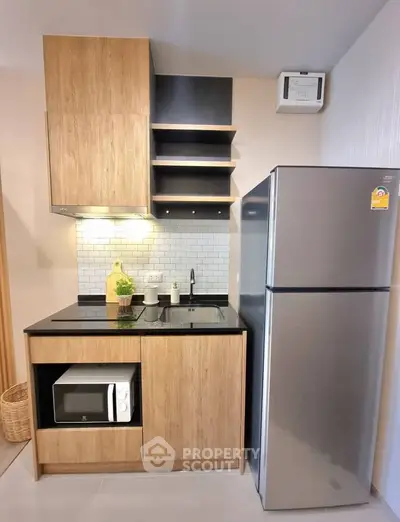 Modern compact kitchen with sleek wooden cabinets and stainless steel appliances
