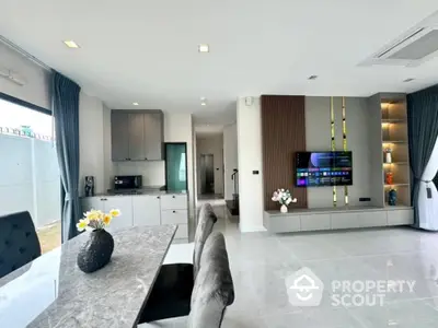 Spacious modern living room seamlessly integrates with a sleek kitchen, featuring high-end appliances, elegant furnishings, and tasteful decor.