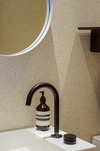 Modern bathroom with stylish black faucet and round mirror