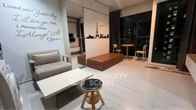 Modern studio apartment with stylish decor and city view, featuring cozy seating and elegant wall art.