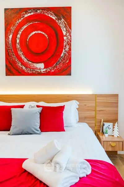 Modern bedroom with vibrant red accents and abstract art