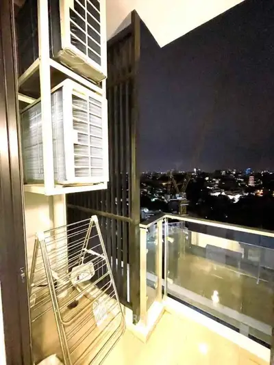 Modern balcony with city view, featuring air conditioning units and drying rack, perfect for urban living.