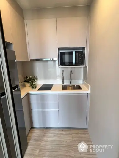 Modern compact kitchen with sleek cabinetry and built-in appliances