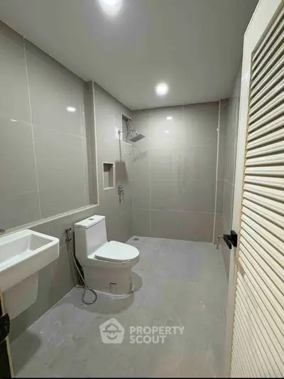 Modern bathroom with sleek tiles and contemporary fixtures in a real estate property.