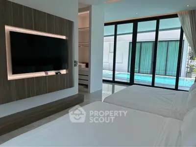 Luxurious bedroom with pool view and modern TV setup
