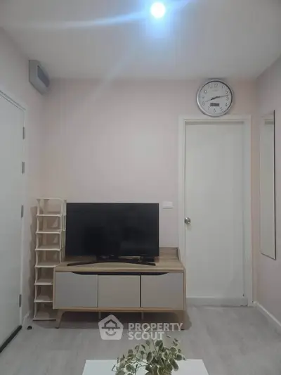 Modern living room with sleek TV stand and wall clock, perfect for cozy relaxation.