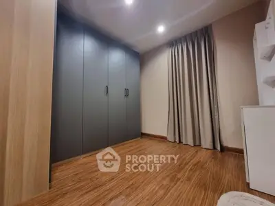 Spacious bedroom with modern wardrobe and elegant wooden flooring