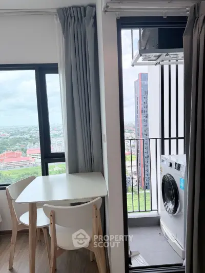 Modern apartment with balcony view and in-unit washing machine, featuring stylish dining area and expansive cityscape.