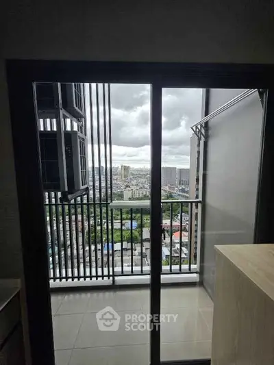 Modern apartment balcony with stunning city view through glass doors.
