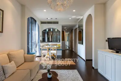 Elegant open-plan living space with gleaming hardwood floors, modern furniture, and a seamless transition to a well-lit dining area, perfect for entertaining.