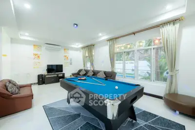 Spacious living room with pool table and modern decor, perfect for entertainment.