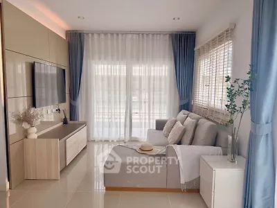 Elegant living room with modern decor, large windows, and cozy seating area.