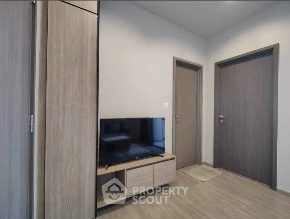Modern living room with sleek wooden furniture and flat-screen TV, perfect for cozy relaxation.