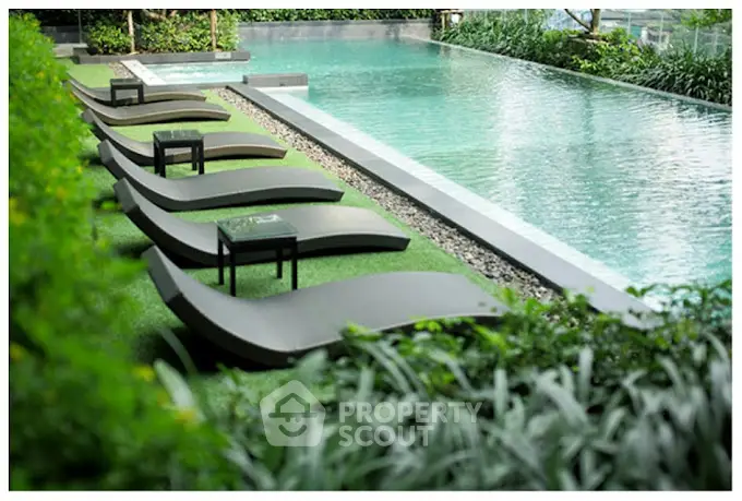 Luxurious outdoor pool area with modern loungers and lush greenery, perfect for relaxation and leisure.