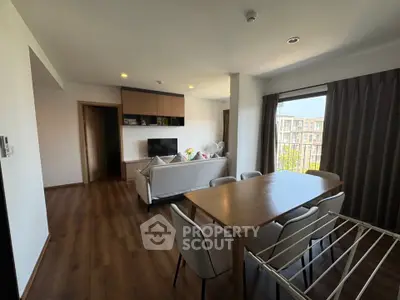 Spacious living room with modern dining area and large window view
