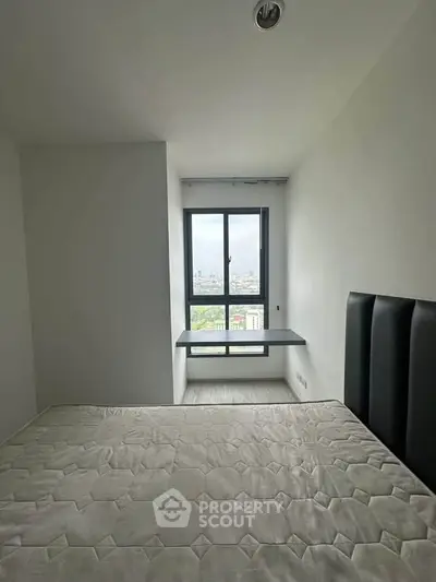 Modern bedroom with city view and minimalist design, featuring a large window and sleek headboard.