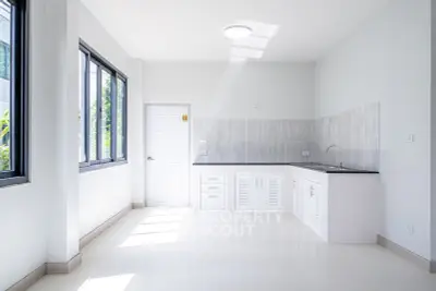 Bright modern kitchen with sleek white cabinetry and large windows
