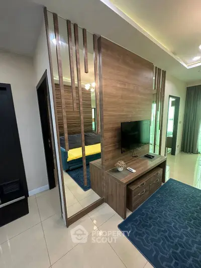 Modern living room with stylish wood paneling and sleek TV setup, featuring elegant decor and contemporary design.