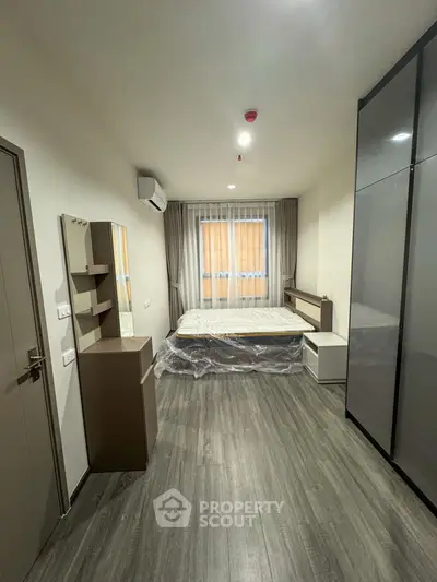 Modern bedroom with sleek design, featuring a large window and stylish furniture.