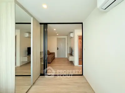 Modern living room with mirrored wardrobe and air conditioning in a stylish apartment.