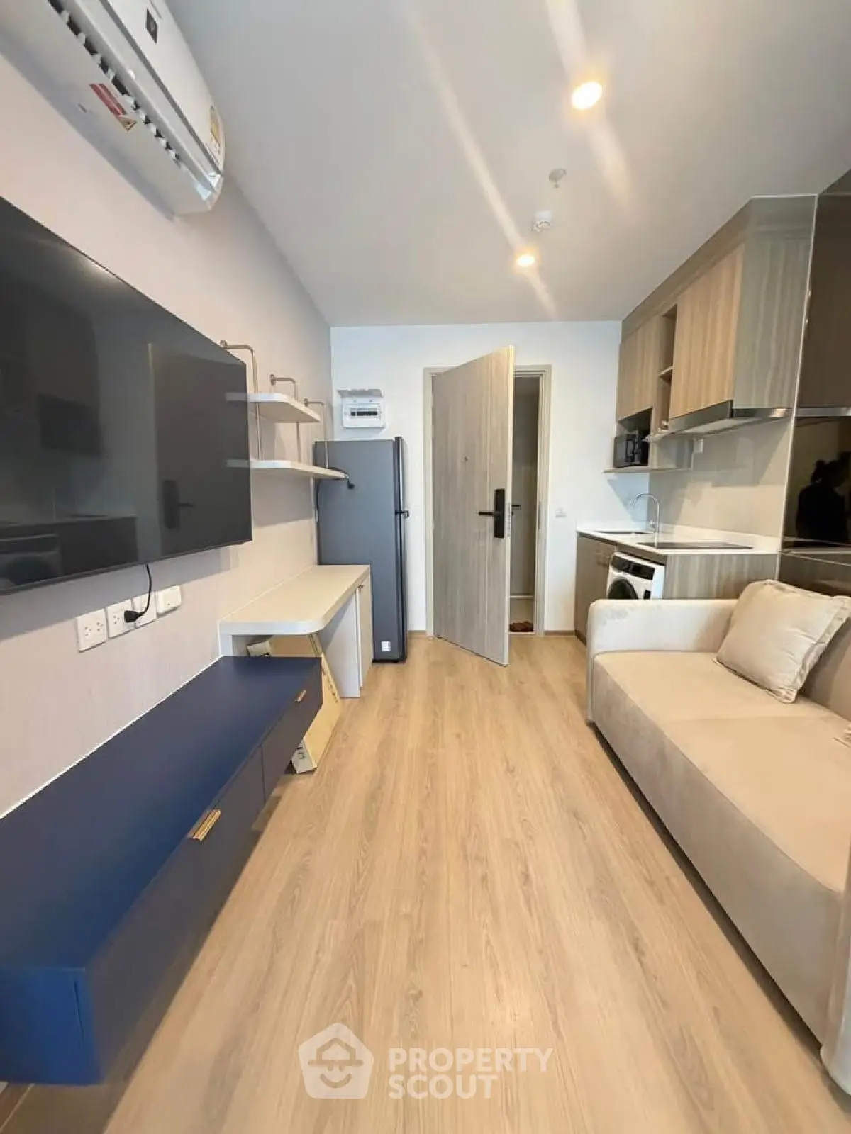 Modern living room with sleek furniture and open kitchen layout in a stylish apartment.