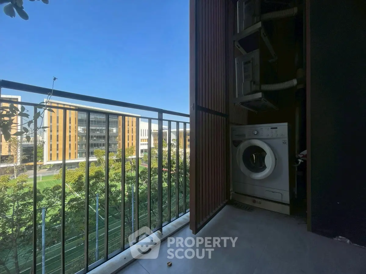 Modern balcony with washing machine and scenic view of urban buildings.