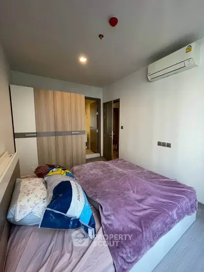 Cozy bedroom with modern air conditioning and stylish wardrobe in a contemporary apartment.