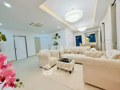 Luxurious living room with elegant chandeliers and plush sofas in a modern apartment.
