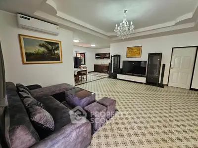 Spacious living room with elegant chandelier and modern furniture