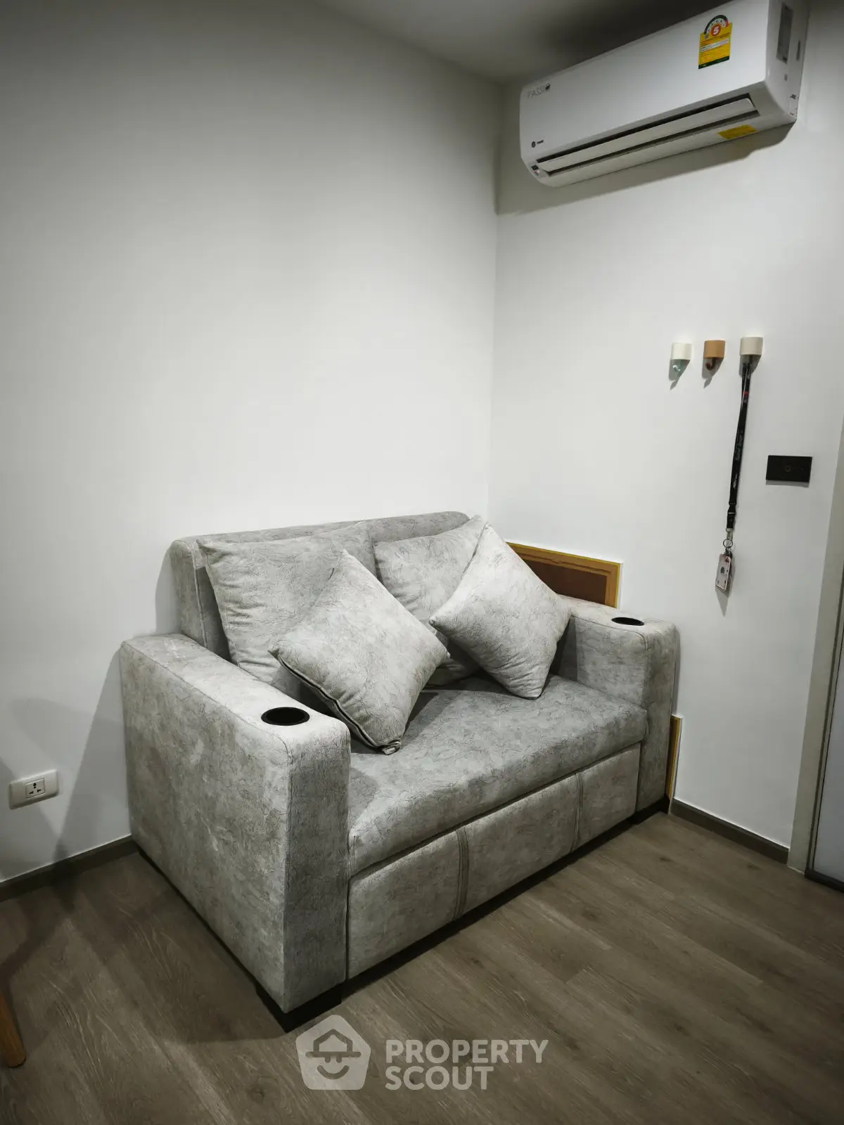 Cozy living room with modern gray sofa and air conditioning unit, perfect for relaxation.