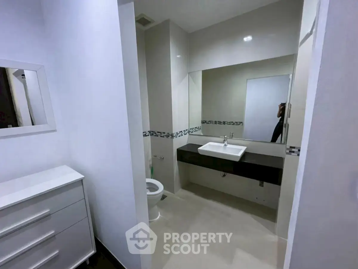 Modern bathroom with sleek design and large mirror in a contemporary home.