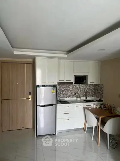 Modern kitchen with sleek cabinets and dining area in a stylish apartment.