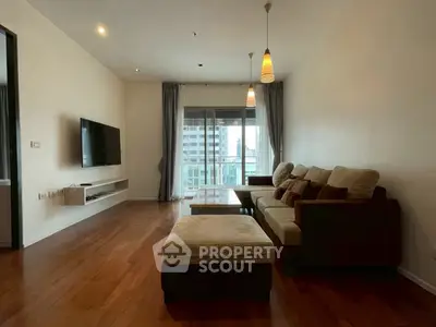 Spacious living room with modern decor and city view balcony, perfect for urban living.