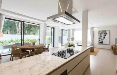 Luxurious open-plan kitchen and living area with pool view and modern decor