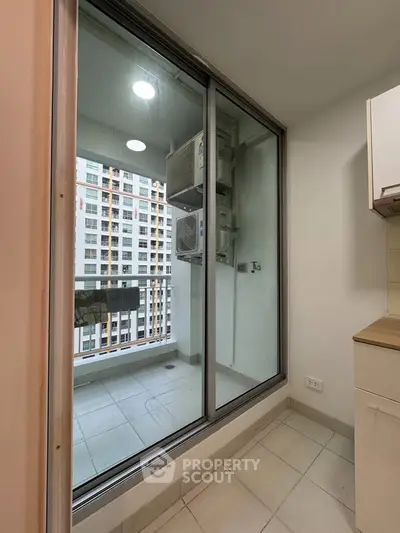 Modern apartment balcony with sliding glass doors and city view