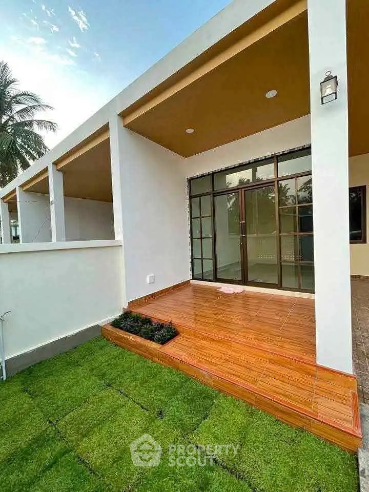 Charming modern home exterior with spacious patio and lush green lawn